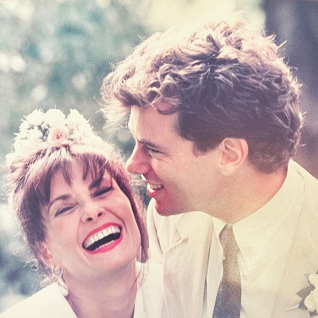 Stephen Hains in a white shirt with his wife in white dress.